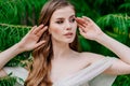 portrait. beautiful woman with light eyes in white dress against of green leaves Royalty Free Stock Photo