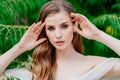 portrait. beautiful woman with light eyes in white dress against of green leaves Royalty Free Stock Photo