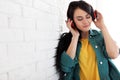 Portrait of beautiful woman listening to music with headphones near brick wall Royalty Free Stock Photo