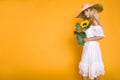 Portrait of a beautiful woman with long blond hair, wearing a white dress, holding sunflowers. Royalty Free Stock Photo