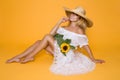 Portrait of a beautiful woman with long blond hair, wearing a white dress, holding sunflowers. Royalty Free Stock Photo