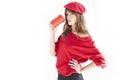 Portrait of Beautiful woman with long hair wearing red hat and sweater holds paper disposable coffee cup. Royalty Free Stock Photo