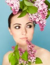 Portrait of beautiful woman with makeup and branch of lilac