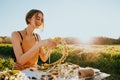 Portrait of beautiful woman making wreath of flowers dandelions on flowering field. Summer lifestyle, nature lover and freedom Royalty Free Stock Photo