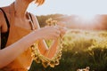 Portrait of beautiful woman making wreath of flowers dandelions on flowering field. Summer lifestyle, nature lover and freedom Royalty Free Stock Photo