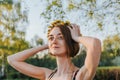 Portrait of beautiful woman making wreath of flowers dandelions on flowering field. Summer lifestyle, nature lover and freedom Royalty Free Stock Photo