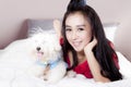 Beautiful woman and Maltese dog on bedroom