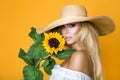 Portrait of a beautiful woman with long blond hair, wearing a white dress, holding sunflowers. Royalty Free Stock Photo