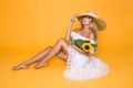 Portrait of a beautiful woman with long blond hair, wearing a white dress, holding sunflowers. Royalty Free Stock Photo