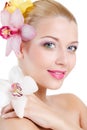 Portrait of Beautiful woman With Orchid Flower in her hair.Beautiful Model Woman Face. Perfect Skin. Professional Make-up.Makeup. Royalty Free Stock Photo