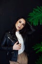 Portrait of a beautiful brunette woman of oriental appearance and green plant