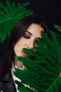 Portrait of a beautiful brunette woman of oriental appearance and green plant