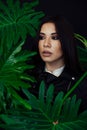 Portrait of a beautiful brunette woman of oriental appearance and green plant