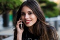 Portrait of a beautiful woman with perfect white smile talking on the mobile phone outdoor Royalty Free Stock Photo