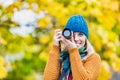 Portrait of beautiful woman photographing lovely maple trees in park