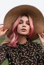 Portrait beautiful woman with piercing with colorful hair with sexy lips with clean skin in straw fashion hat in black stylish