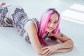 Portrait of a beautiful woman with pink hair on a white background