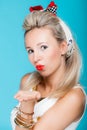 Portrait beautiful woman pinup girl retro style blowing a kiss - flirty on blue Royalty Free Stock Photo