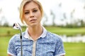 Portrait of a beautiful woman playing golf on a green field outdoors background. The concept of golf, the pursuit of