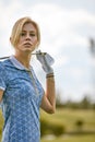 Portrait of a beautiful woman playing golf on a green field outdoors background. The concept of golf, the pursuit of