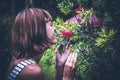 Portrait of beautiful woman posing among blooming asian flowers on Bali island, Indonesia.