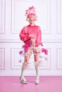 Portrait of beautiful woman, queen wearing pink wig and holding can with sweets over luxury interior background. Sweet Royalty Free Stock Photo