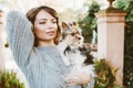 Portrait of a beautiful woman with rare little size purebreed dog - Biewer Terrier. Girl is walking in the park with her cute