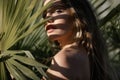 Portrait of beautiful woman with shadows of palm leaf on face. Young beautiful woman with shadow of palm leaves on face