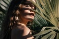 Portrait of beautiful woman with shadows of palm leaf on face. Young beautiful woman with shadow of palm leaves on face