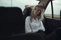 Portrait of beautiful woman sitting relaxed on the back seat of the car and looking at the window thoughtfully Royalty Free Stock Photo