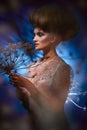 Portrait of a beautiful woman with stylish hairdo posing with big dandelion Royalty Free Stock Photo