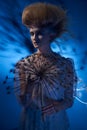 Portrait of a beautiful woman with stylish hairdo posing with big dandelion Royalty Free Stock Photo