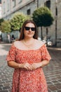 Portrait beautiful woman in sunglasses in street. Happy tourist travels in Europe. Vacation concept by exploring