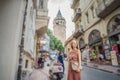 Portrait of beautiful woman tourist with view of Galata tower in Beyoglu, Istanbul, Turkey. Turkiye