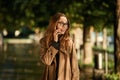 Portrait of beautiful woman using cell phone while walking through empty boulevard Royalty Free Stock Photo