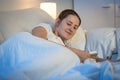 Portrait of beautiful woman using digital tablet in bed at night Royalty Free Stock Photo