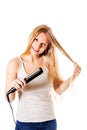 Portrait of beautiful woman using hair straighteners.