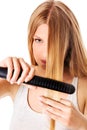 Portrait of beautiful woman using hair straighteners.