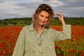 Portrait of beautiful woman are wearing casual clothes in field of poppy flowers. Girl on spring poppy field. Beautiful Royalty Free Stock Photo