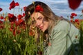 Portrait of beautiful woman are wearing casual clothes in field of poppy flowers. Summer. Girl on spring poppy field. Royalty Free Stock Photo