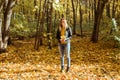 Portrait of beautiful woman holds autumn leaves. Stylish youth and fall season concept. Royalty Free Stock Photo