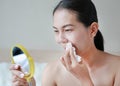 Portrait of beautiful woman wiping lipstick at her mouth with a tissue paper. Beauty Concept