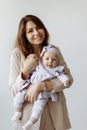 Portrait of beautiful woman with cute newborn baby girl in studio. Loving mother hold adorable little daughter in arms Royalty Free Stock Photo