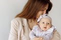 Portrait of beautiful woman with cute newborn baby girl in studio. Loving mother hold adorable little daughter in arms Royalty Free Stock Photo