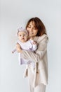 Portrait of beautiful woman with cute newborn baby girl in studio. Loving mother hold adorable little daughter in arms Royalty Free Stock Photo