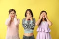 Portrait of beautiful women hearing no evil, seeing no evil and speaking no evil, on color background