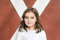 Portrait of a Beautiful 5-year Old Girl in Front of a Red Barn Door Royalty Free Stock Photo