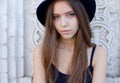 Portrait of a beautiful young adult girl in black hat outdoor