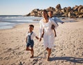 Portrait of a beautiful young african american mother at the beach with her two children. Little girl sitting on her Royalty Free Stock Photo