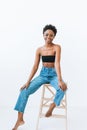 Portrait of beautiful young African American woman in black top and blue jeans isolated on the white background Royalty Free Stock Photo